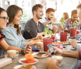 Ein Bild von einer Gruppe von Menschen die am Tisch sitzen und lächeln, auf dem Tisch sind Kaffeetassen und Kuchen