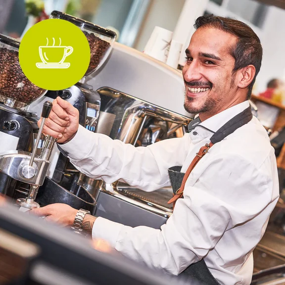 Ein lächelnder Mann der seine Arbeit als Barista tätigt