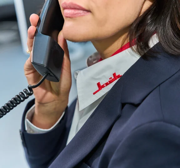 Das Bild zeigt eine weibliche Sicherheitskraft, die telefoniert.