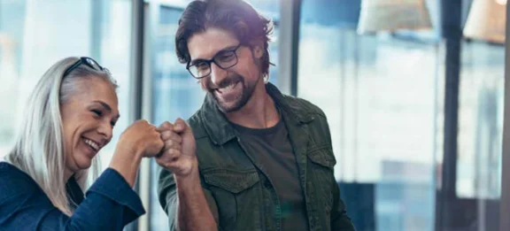 ein lächelnder Mann und Frau schlagen mit der Faust ein