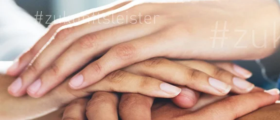 Ein Bild von vielen Händen die aufeinander liegen und ein Turm bilden, auf dem Bild ist oft der Schriftzug: #zukunftsleister