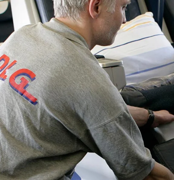 Ein männlicher Arbeiter kontrolliert im Rahmen der sogenannten Cabin Seach die Sitze im Flugzeug.